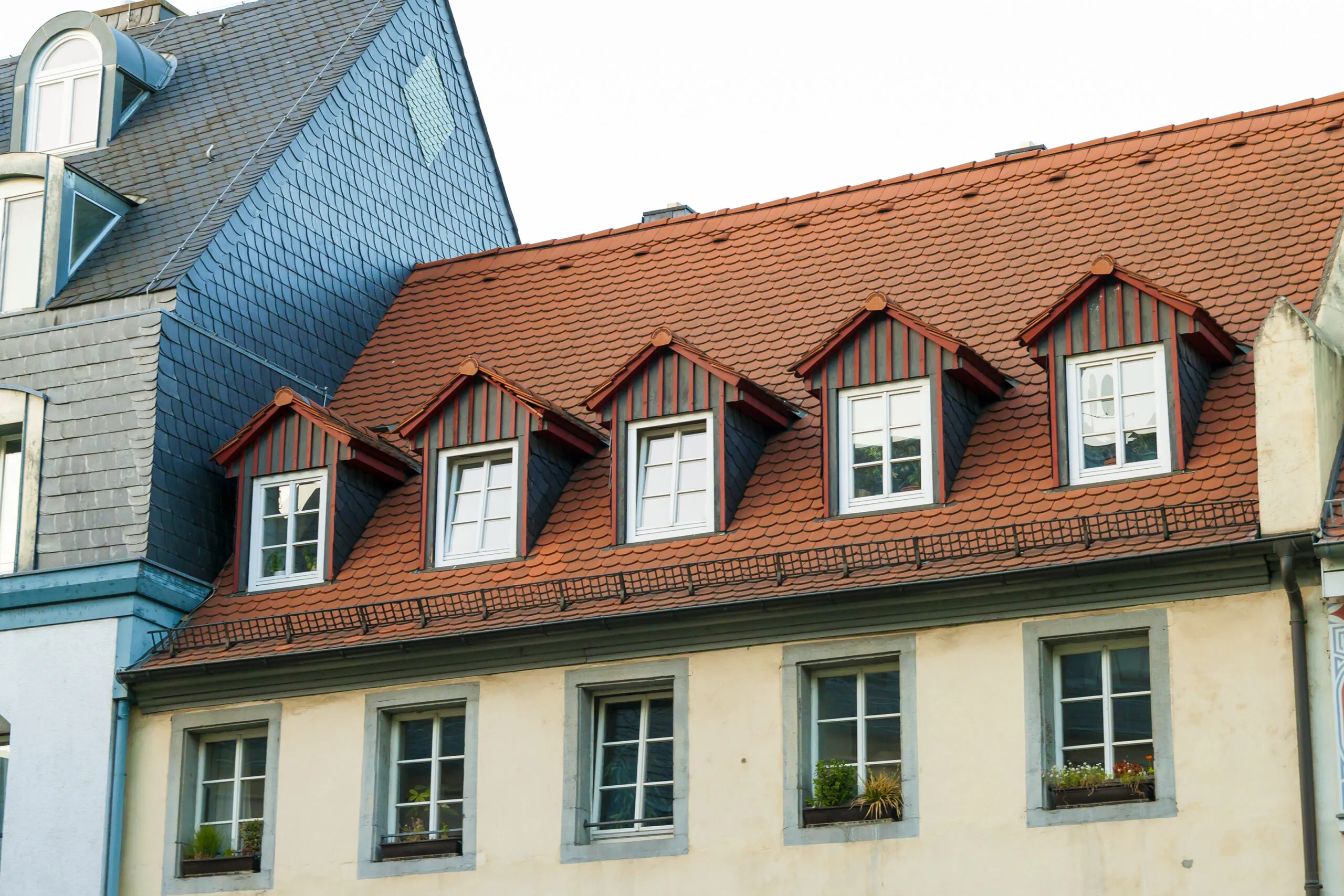 Roofs of old houses with roof windows and orange roof tiles in German city